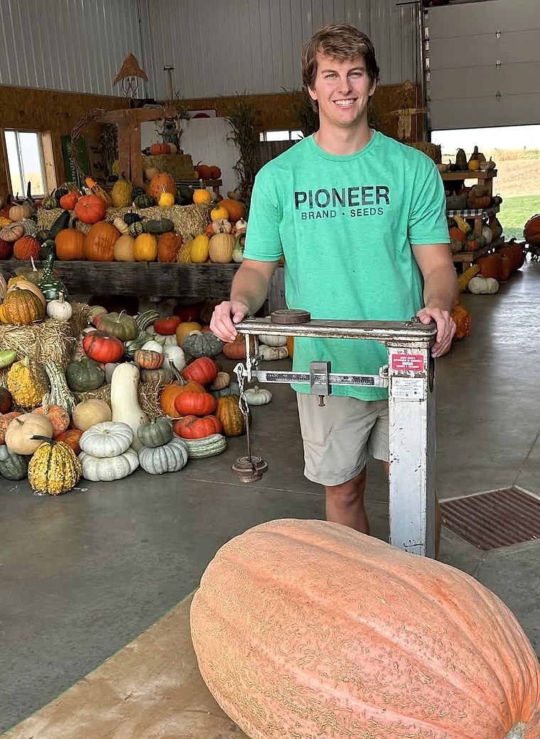 Ethan Kooima standing beside a produce scale at the family pumpkin farm